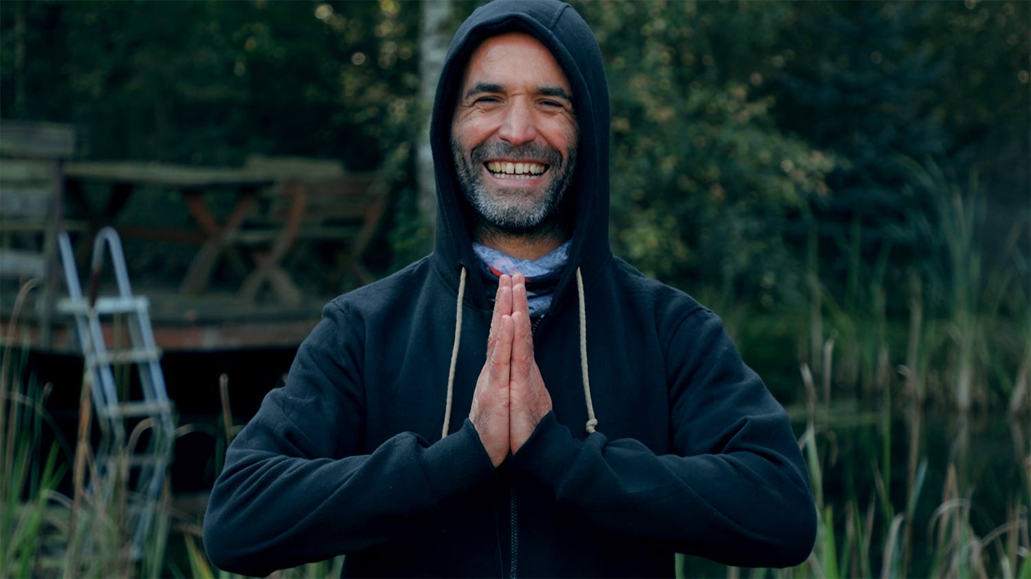 Mężczyzna w kapturze podczas sesji mindfulness na warsztatach rozwoju osobistego dla mężczyzn.